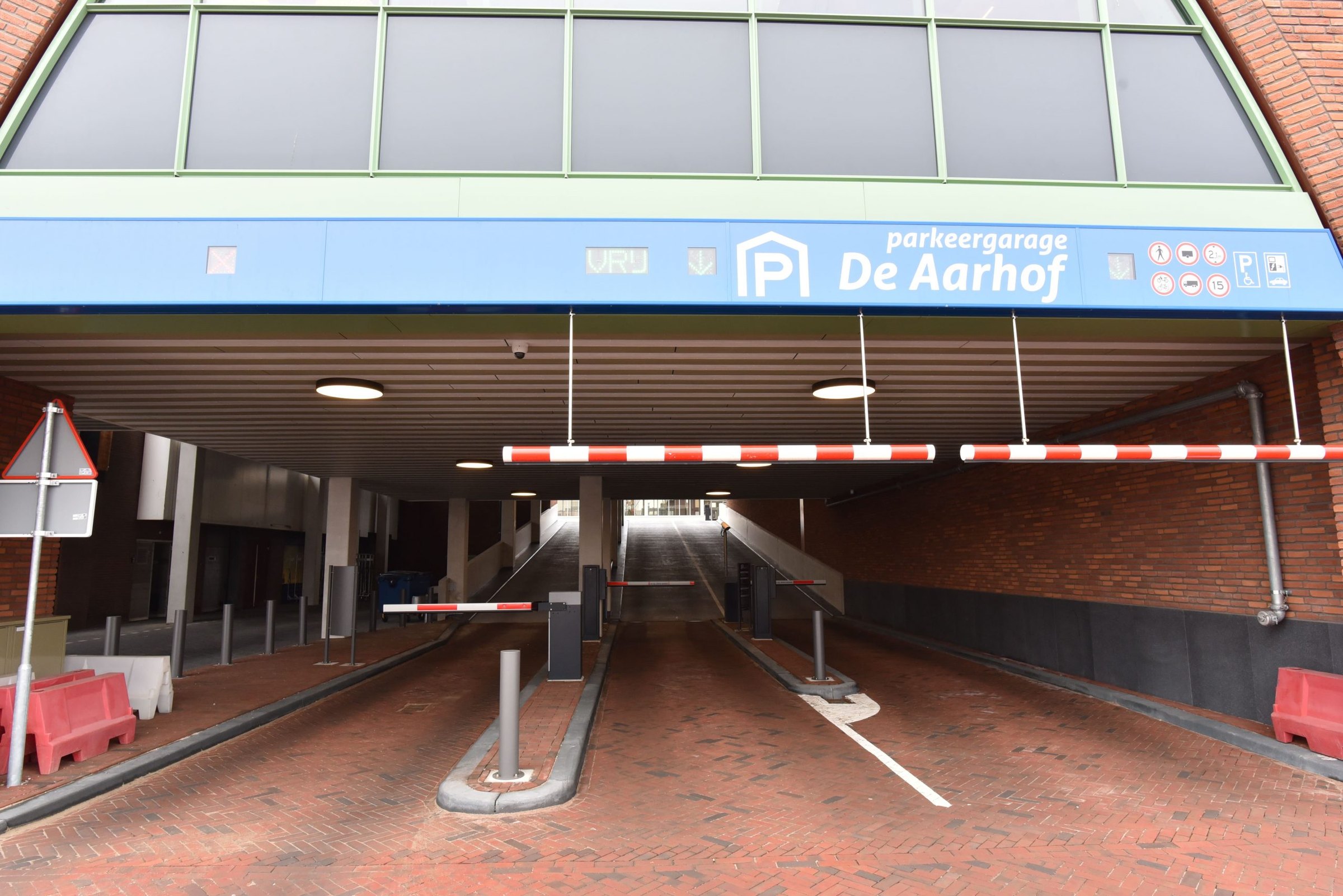 De in- en uitrit van parkeergarage De Aarhof met het bord, de slagbomen en het gestreepte plafond
