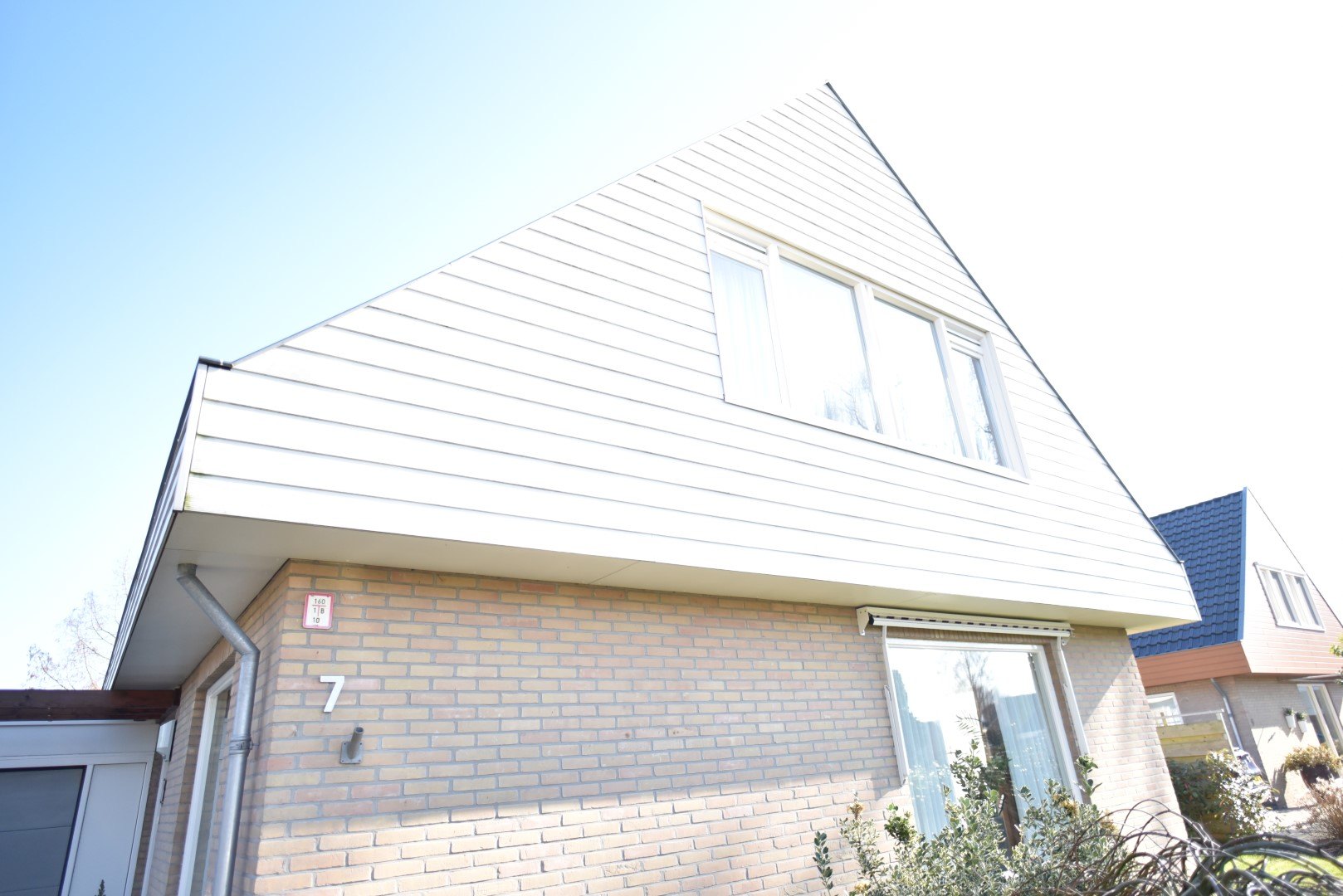 De puntgevel van de woning in Lemmer met witte Cedral Classic