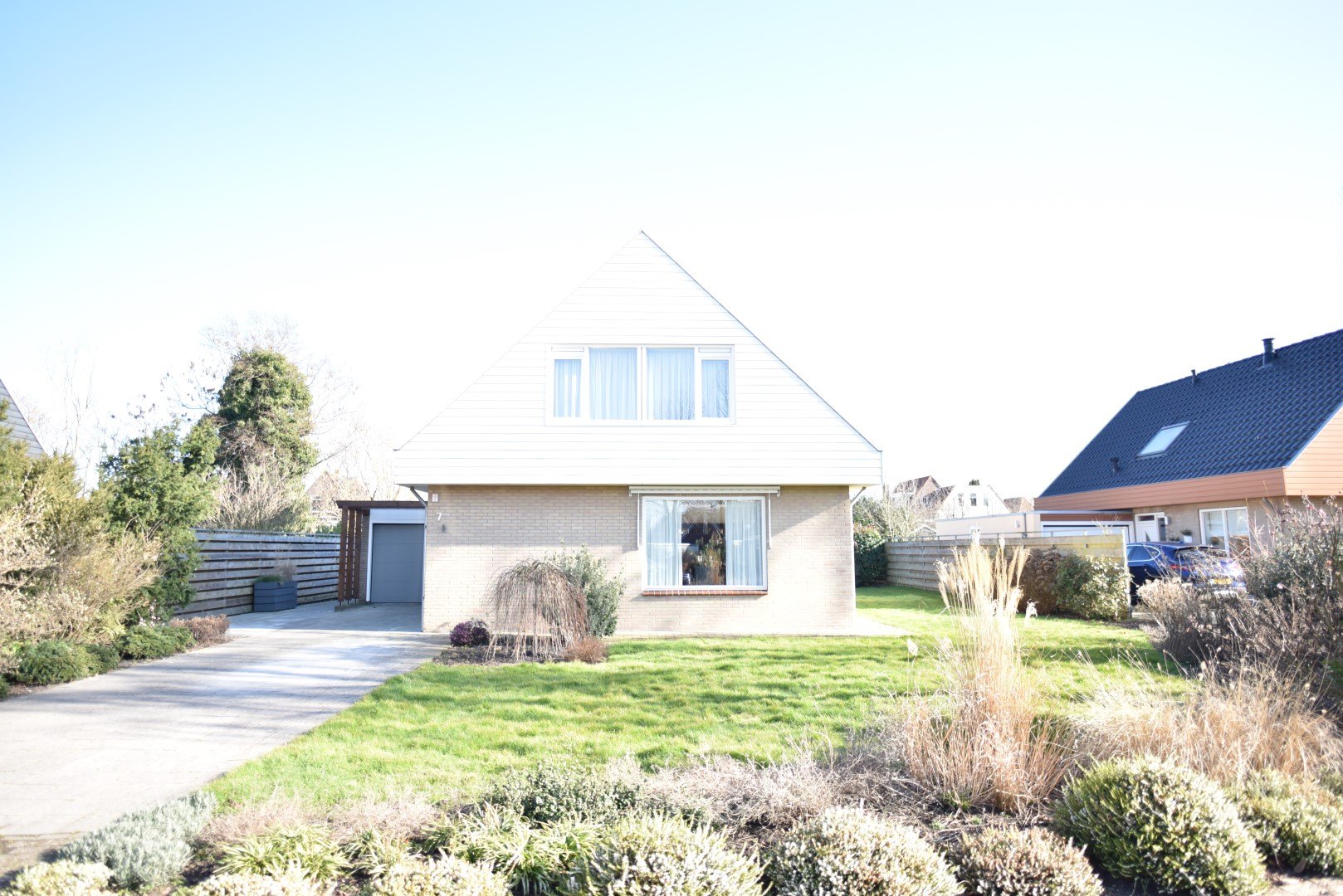 Witte woning in Lemmer met gepotdekselde Cedral Classic en een tuin