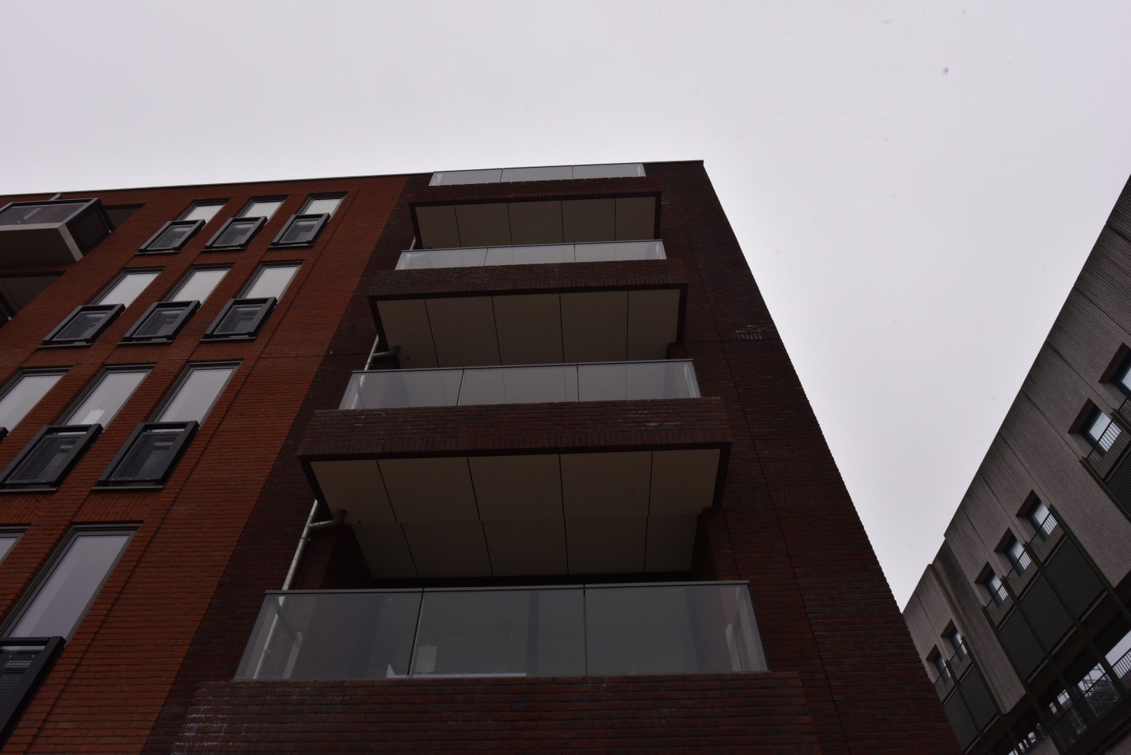 Appartementengebouw Plaza West in Haarlem van onderaf, rode baksteen met balkons